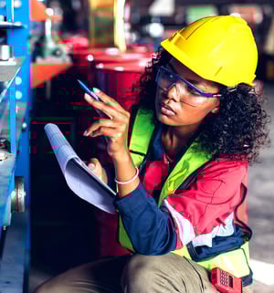 factory worker examining manufacturing equipment